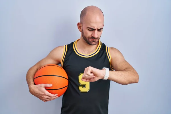 Joven Calvo Con Barba Vistiendo Uniforme Baloncesto Sosteniendo Pelota Comprobando —  Fotos de Stock