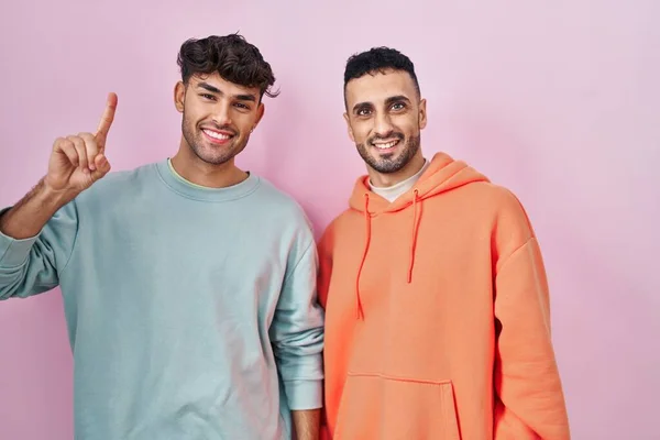 Jong Hispanic Gay Paar Staande Roze Achtergrond Tonen Wijzen Omhoog — Stockfoto