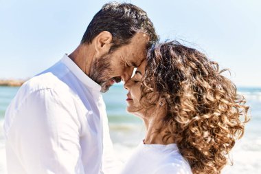 Orta yaşlı İspanyol çift sahilde sarılıyor..