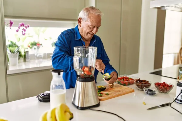 Hombre Mayor Sonriendo Confiado Cortando Aguacate Cocina —  Fotos de Stock