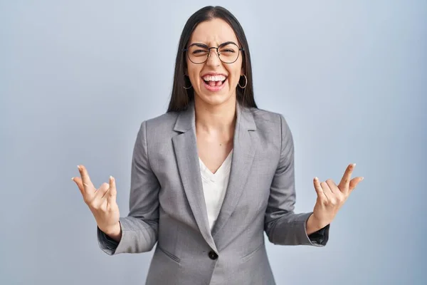 西班牙裔商业女性戴着眼镜大喊着 用疯狂的表情举手表决摇滚符号 音乐明星 沉重的概念 — 图库照片