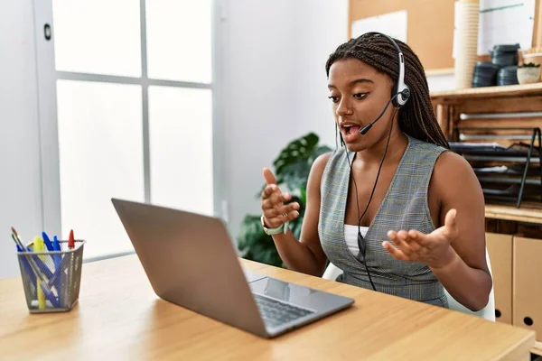 Young african american woman call center agent having video call at office