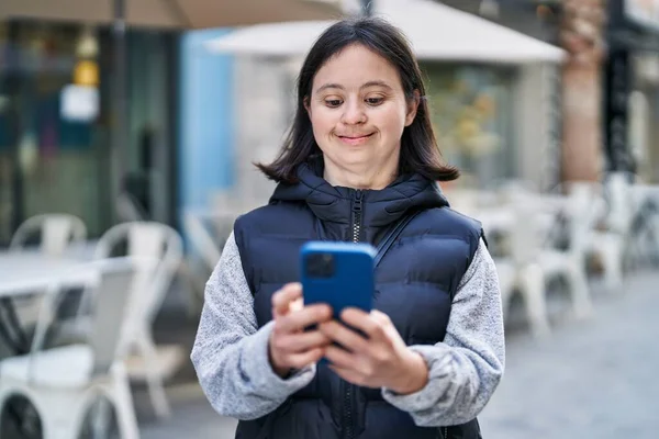 在街上用智能手机自信地微笑着的患有唐氏综合征的年轻女性 — 图库照片