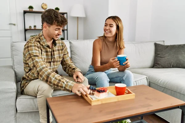 Jovem Casal Hispânico Sorrindo Feliz Tomando Café Manhã Sentado Sofá — Fotografia de Stock