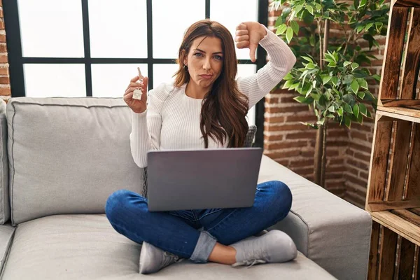 Young Brunette Woman Using Laptop Holding Keys New Home Angry — Stock Photo, Image