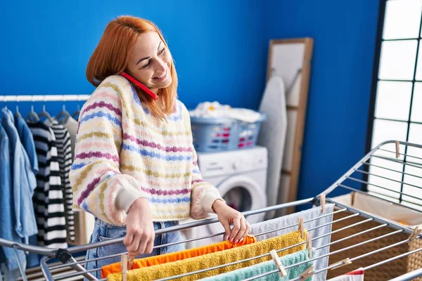 Junge Kaukasierin Spricht Auf Smartphone Und Hängt Kleider Wäscheleine Waschküche — Stockfoto