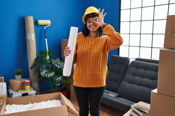 Junge Hispanische Frau Steht Auf Neuem Zuhause Mit Blaupausen Lächelnd — Stockfoto