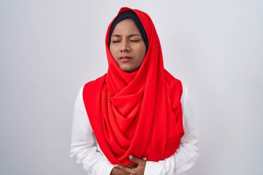 Genç Arap kadın midesinde geleneksel başörtüsü olan bir başörtüsü takıyor çünkü hazımsızlık, acı verici bir hastalık kendini iyi hissetmiyor. Ağrı kavramı. 