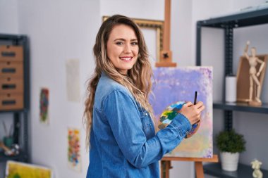 Young woman artist smiling confident drawing at art studio
