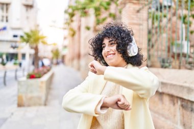Ortadoğulu genç kadın sokaklarda müzik dinleyip dans ediyor.