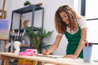 Sanat stüdyosunda kendine güvenen güzel İspanyol bir sanatçı çiziyor.