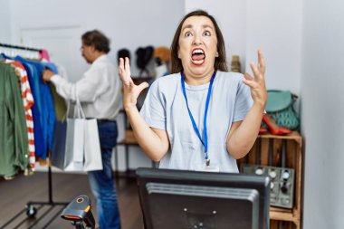 Orta yaşlı İspanyol kadın perakende mağazasında yönetici olarak çalışıyor. Deli gibi bağırıyor ve bağırıyor. Saldırgan bir ifade ve kollar havada. hüsran kavramı. 