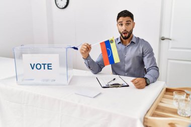 Siyasi seçim kampanyasında sakallı genç yakışıklı adam Venezuela bayrağını tutuyor. 
