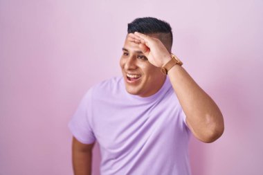 Pembe arka planda duran genç İspanyol adam çok mutlu ve gülümsüyor. arama kavramı. 