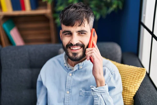 Young Hispanic Man Talking Smartphone Sitting Sofa Home — Stockfoto