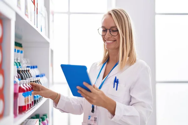 Young Blonde Woman Pharmacist Using Touchpad Working Pharmacy — Foto Stock