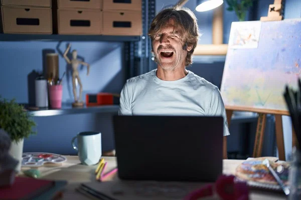 Orta Yaşlı Bir Adam Geceleri Dizüstü Bilgisayarla Sanat Stüdyosunda Oturuyor — Stok fotoğraf