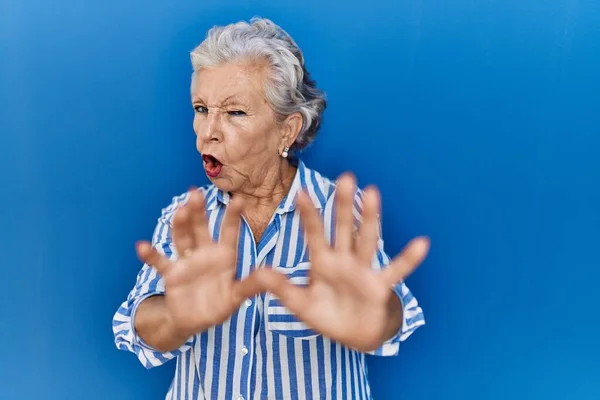 Mavi Arka Planda Gri Saçlı Yaşlı Bir Kadın Korku Ifadesinden — Stok fotoğraf