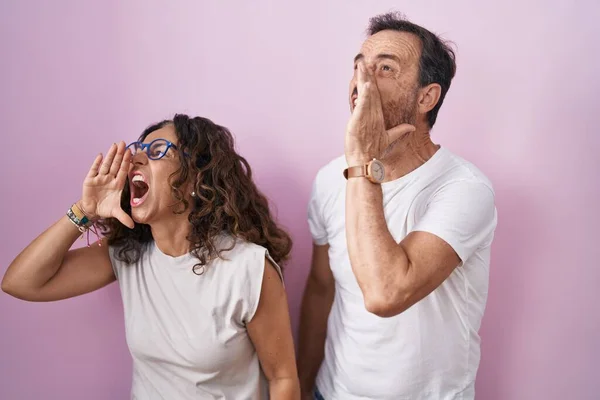 Medelåldern Hispanic Par Tillsammans Över Rosa Bakgrund Skriker Och Skriker — Stockfoto