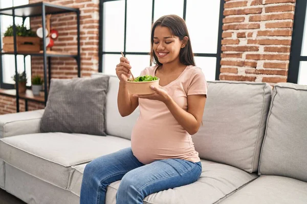 Jonge Latijnse Vrouw Zwanger Eten Salade Zitten Bank Thuis — Stockfoto