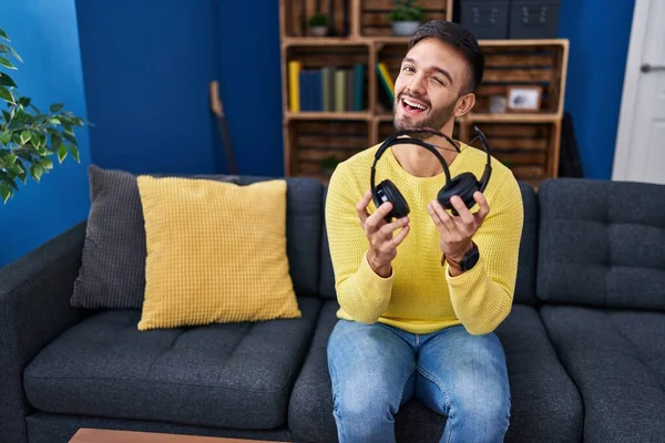 Hispanischer Mann Mit Kaputten Kopfhörern Der Augenzwinkernd Die Kamera Blickt — Stockfoto