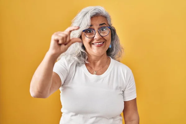Sarı Arka Planda Duran Gri Saçlı Orta Yaşlı Bir Kadın — Stok fotoğraf