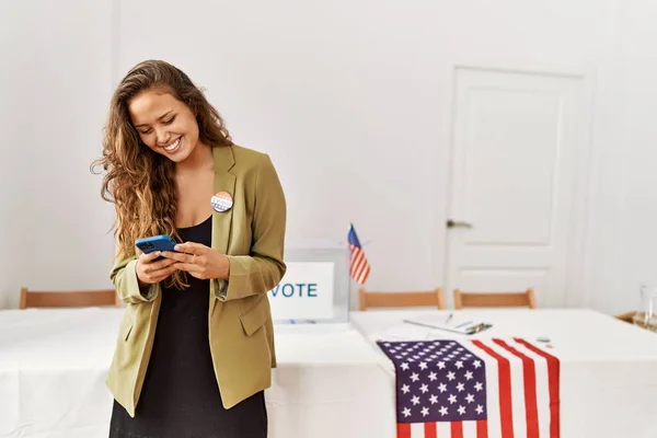 若い美しいヒスパニック系女性の選挙テーブル大統領は 選挙大学でスマートフォンを使用して — ストック写真