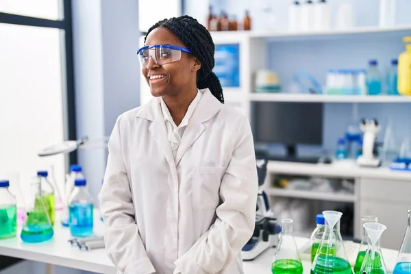 側を探している科学研究所で働くアフリカ系アメリカ人女性 自然な顔と自信を持って笑顔でプロファイルポーズをリラックス — ストック写真
