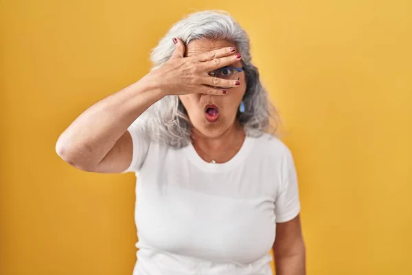 Mulher Meia Idade Com Cabelos Grisalhos Sobre Fundo Amarelo Espreitando — Fotografia de Stock