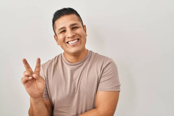 Jovem Hispânico Sobre Fundo Branco Sorrindo Com Rosto Feliz Piscando — Fotografia de Stock