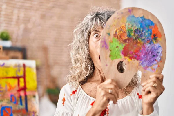 中年妇女牵着油漆漆的调色板 满脸恐惧 惊讶的表情 恐惧和兴奋的脸 — 图库照片