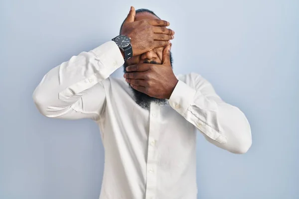 Αφροαμερικάνος Στέκεται Πάνω Από Μπλε Φόντο Καλύπτει Μάτια Και Στόμα — Φωτογραφία Αρχείου