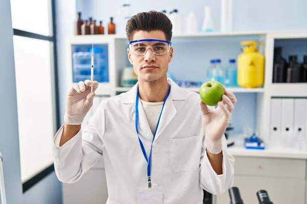 Mladý Hispánec Pracující Laboratoři Vědců Držící Jablko Uvolnil Vážným Výrazem — Stock fotografie