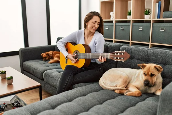 Jovem Hispânica Tocando Guitarra Clássica Sentada Sofá Com Cães Casa — Fotografia de Stock