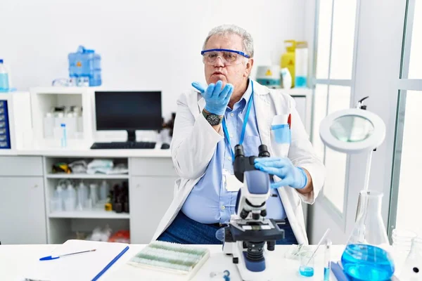 Homem Caucasiano Sênior Trabalhando Laboratório Cientistas Olhando Para Câmera Soprando — Fotografia de Stock