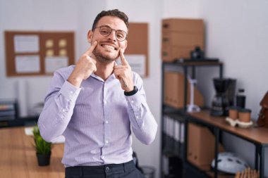 Ofisteki genç İspanyol adam ağzı açık gülümsüyor, parmakları işaret ediyor ve neşeli gülümsemeye zorluyor. 