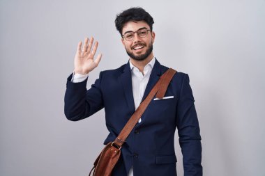 İspanyol sakallı, iş kıyafetleri giyen, merhaba diyen mutlu, güler yüzlü, dost canlısı bir jest. 