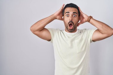 Sakallı İspanyol bir adam arka planda duruyor. Deli ve korkmuş, elleri başında, ağzı açık ve şoktan korkmuş ve şaşırmış. 