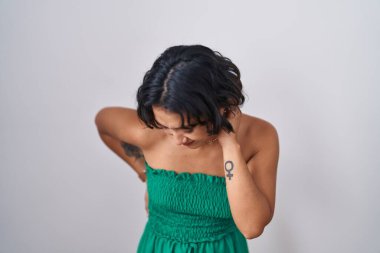 İzole edilmiş arka planda duran genç İspanyol kadın sırt ağrısı çekiyor, elleriyle dokunuyor, kas ağrısı çekiyor. 