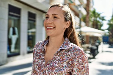 Genç İrlandalı kız gülümsüyor, mutlu bir şekilde şehirde duruyor..