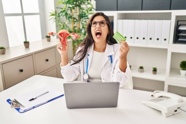 Genç İspanyol doktor kadın elinde anatomik kadın organı ve doğum kontrol hapları tutuyordu. Öfkeliydi, öfkeliydi ve öfkeliydi. Öfkeliydi.. 