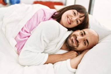 Genç İspanyol çift mutlu bir şekilde gülümsüyor. Yatak odasında yatıyordu..