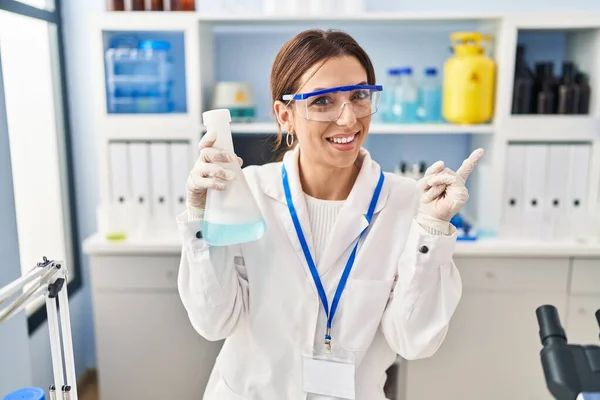 Young Brunette Woman Working Scientist Laboratory Smiling Happy Pointing Hand — 图库照片