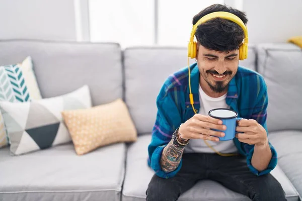 Young Hispanic Man Listening Music Drinking Coffee Home — Stockfoto