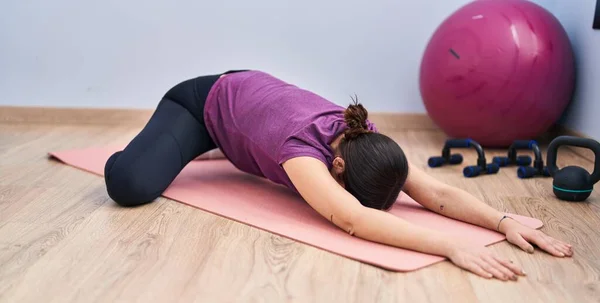 Young woman stretching at sport center