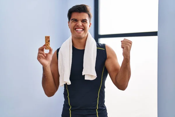 Homem Hispânico Comendo Barra Proteína Como Lanche Energia Saudável Gritando — Fotografia de Stock