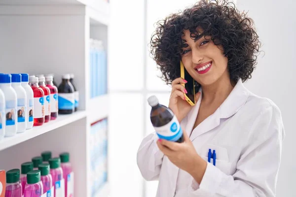 Young Middle East Woman Pharmacist Talking Smartphone Holding Syrup Bottle — Stock Photo, Image
