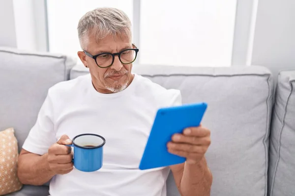 Hombre Pelo Gris Mediana Edad Usando Touchpad Bebiendo Café Casa — Foto de Stock