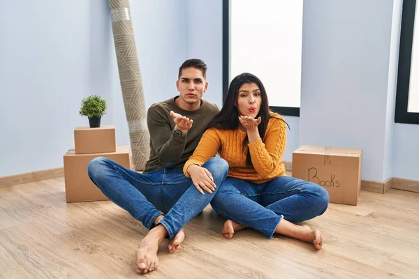 Young Couple Sitting Floor New Home Looking Camera Blowing Kiss — Stock Photo, Image