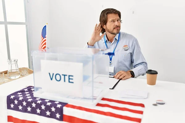 一位英俊的中年男人坐在投票时 面带微笑地站在那里 两手空空地听着流言蜚语 聋的概念 — 图库照片